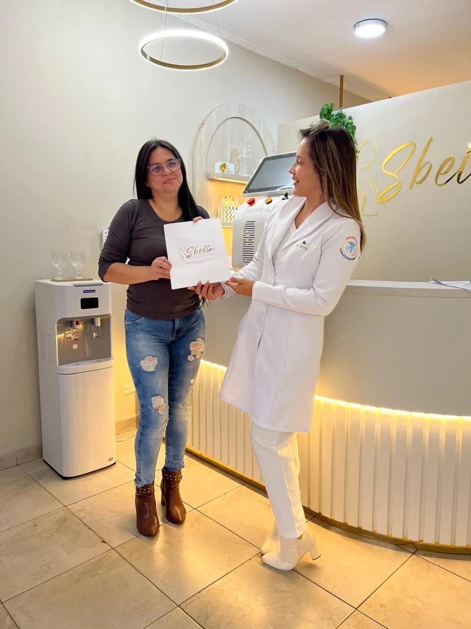 Ruth Ortiz entregando una carpeta de Sbelta a una alumna